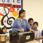 Teacher Guiding Students in a School Music Session